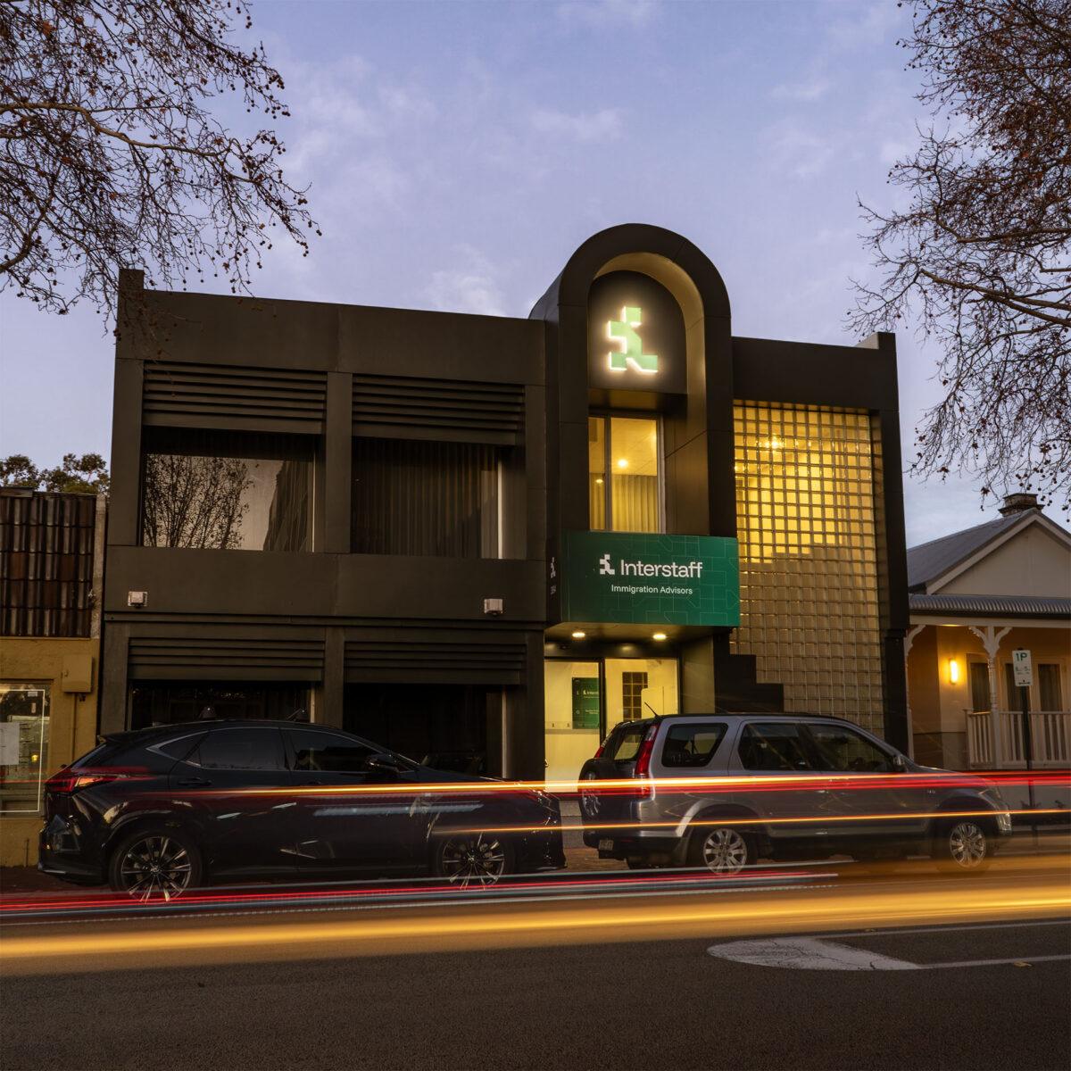 The exterior of the Interstaff Subiaco head office at dusk, featuring illuminated brand signage.