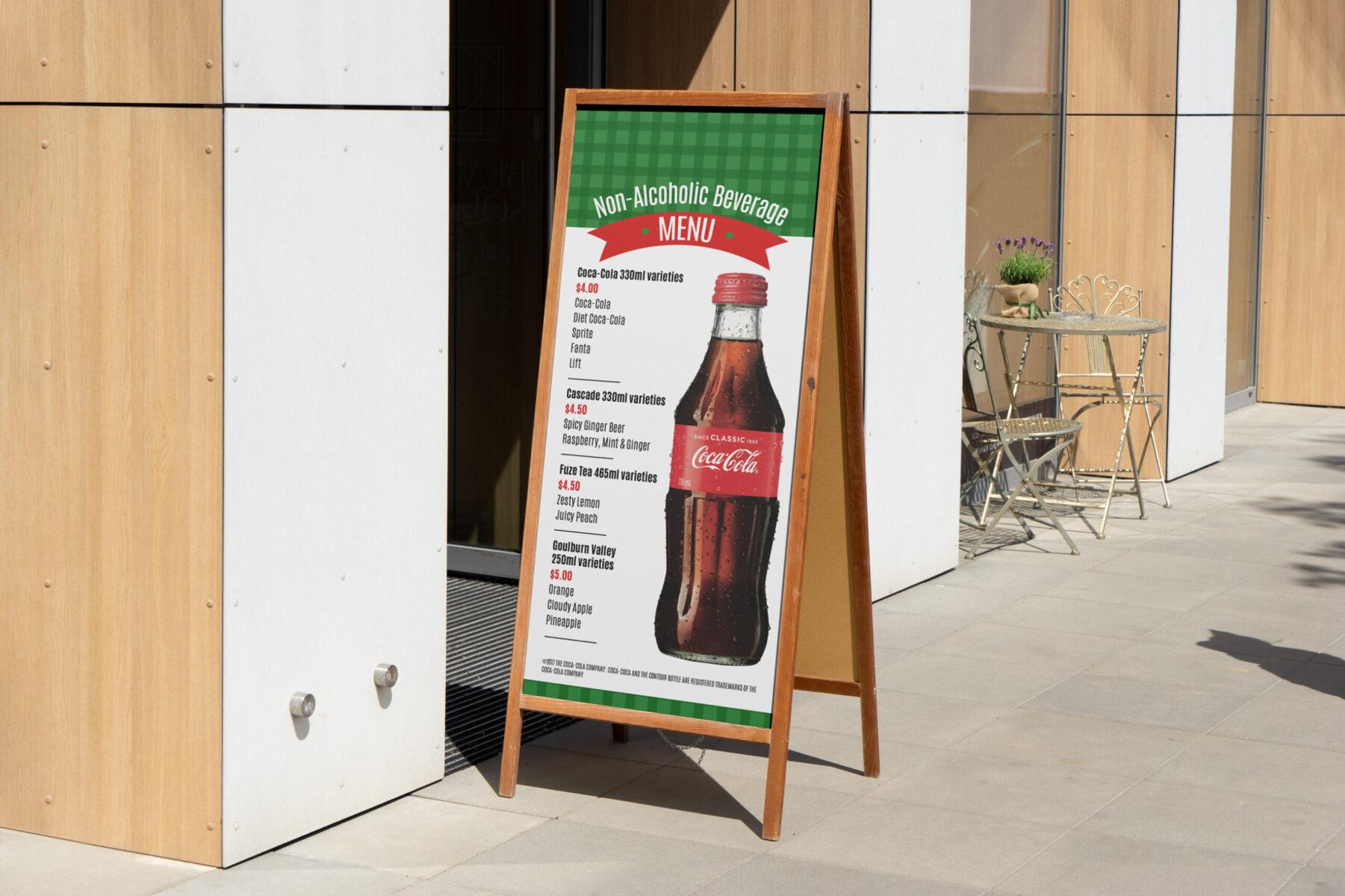 An a-frame sign outside of a food establishment, featuring a menu design with Coca-Cola products.