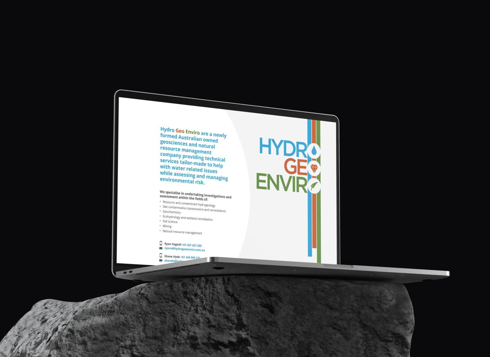 A mockup of a laptop sitting in a dark room, displaying the home page design on the Hydro Geo Enviro website.