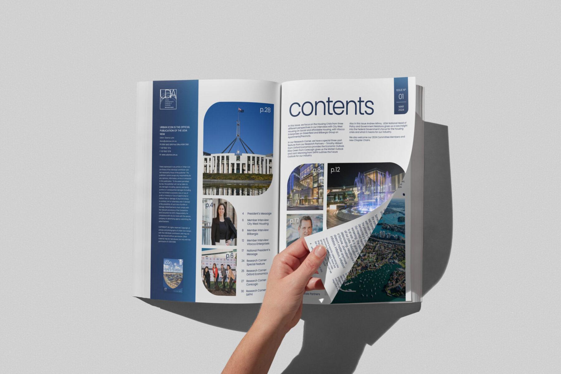 A hand flips through a UDIA NSW magazine. The spread is professionally designed, showing the contents page.