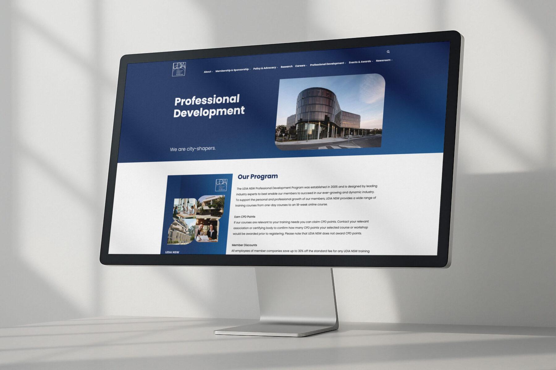 A mockup of a desktop monitor, displaying the home page design for the UDIA NSW website.